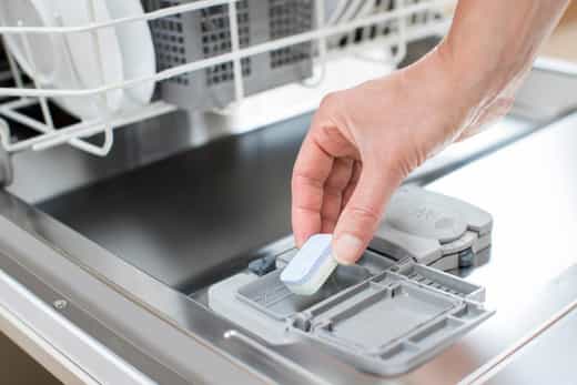 Close Up Of Woman Putting Detergent Tablet Into Dishwater